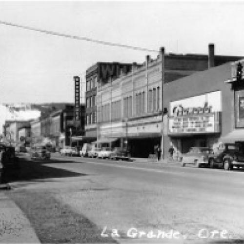 A historic street view of downtown La Grande, where we can see the Granada Theatre, reflecting the everyday life and architectural style of the town during the early to mid-20th century.